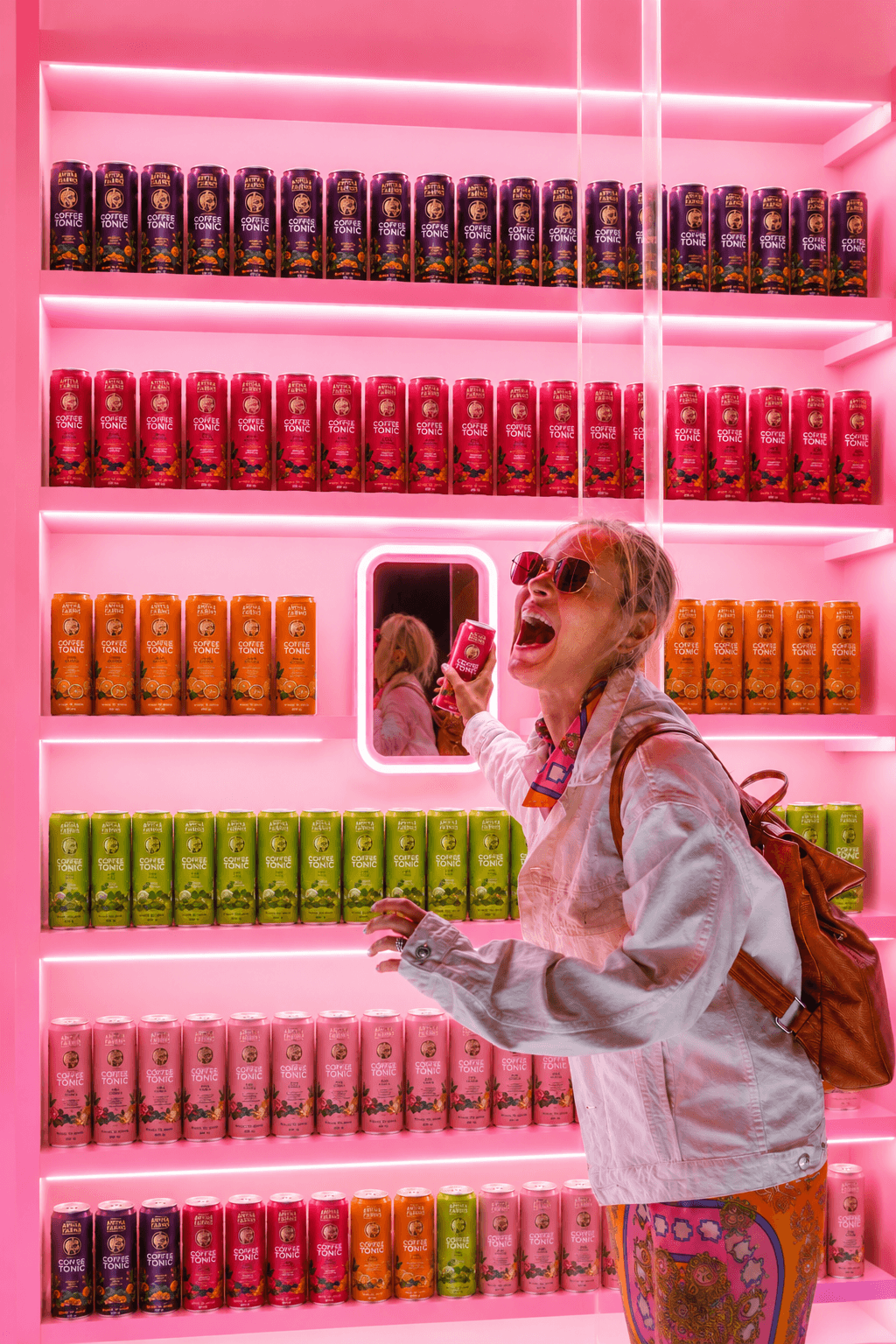 A customer with an Amyra Farms can at a stocked store wall